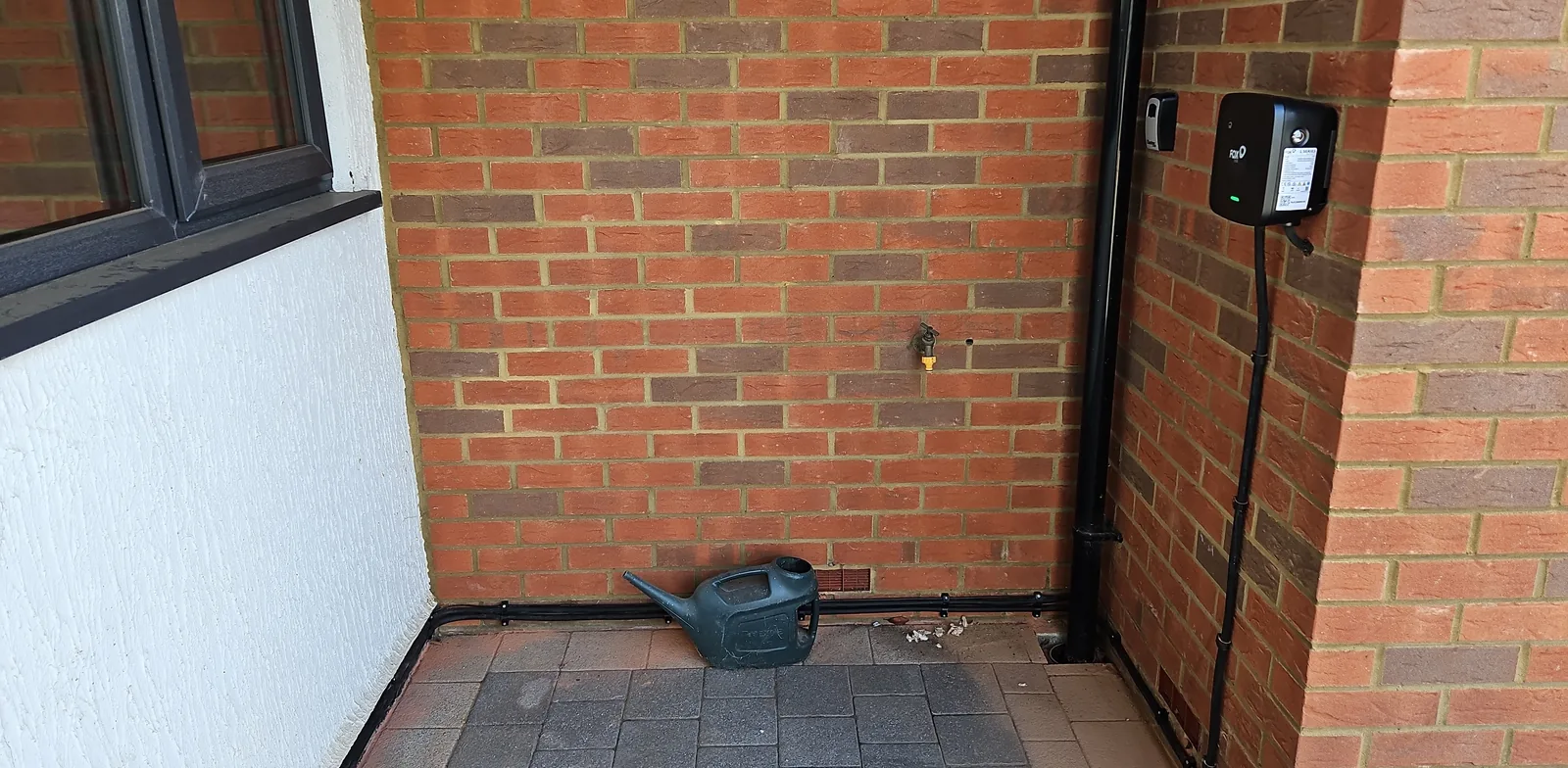 Precision exterior surface cable route along brickwork to EV charger in Bedford